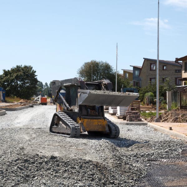construction of a new street. mini excavator bobcat mowing breakstone