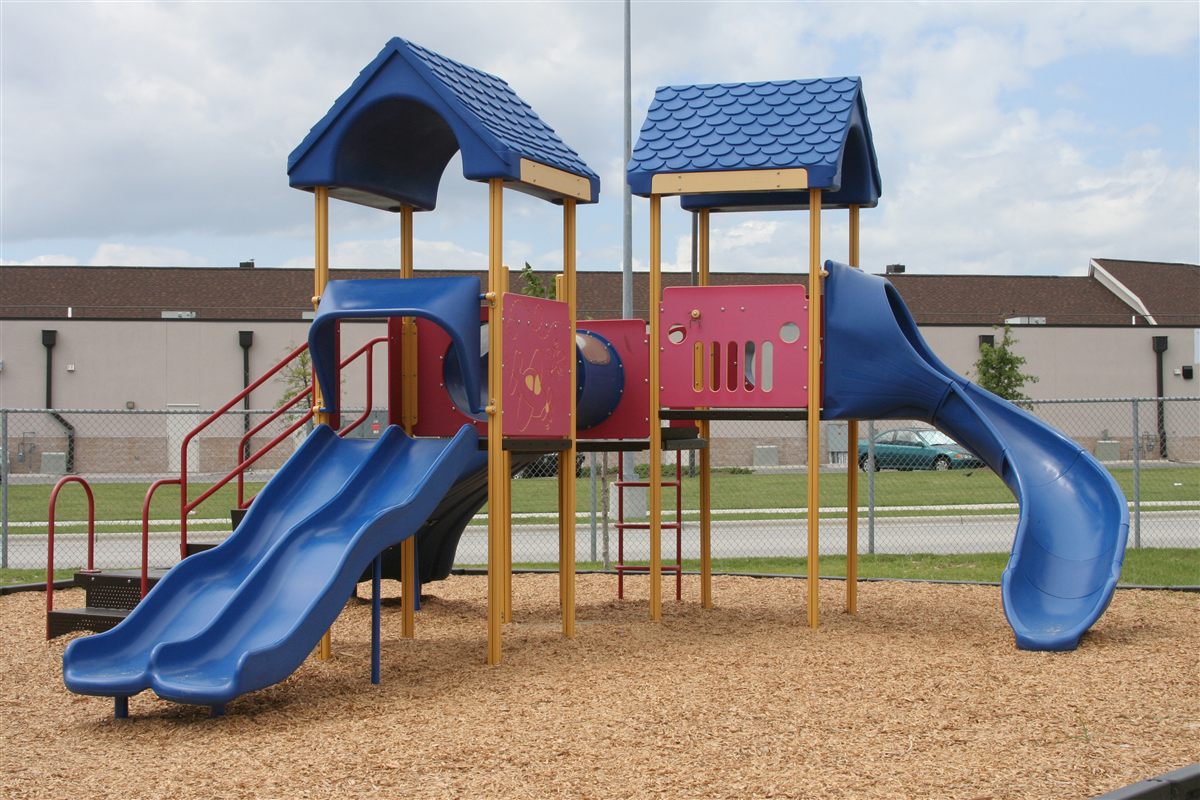 Playground wood chips installed under a school play set